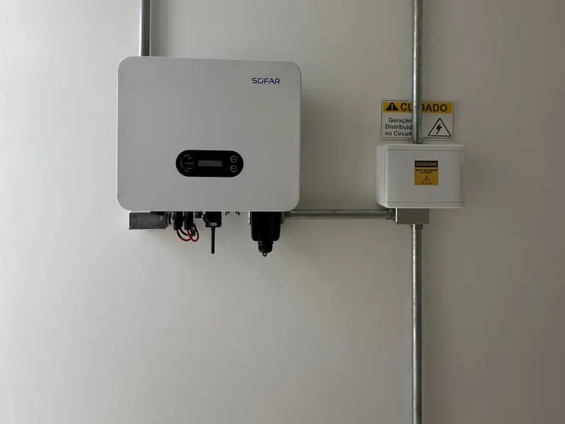 Inversor solar instalado na parede, com sinalização de segurança
